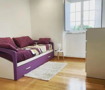 a bedroom with a purple bed and a window at A casa de Lago in Lago