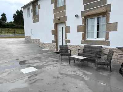 three chairs and a bench in front of a building at A casa de Lago in Lago