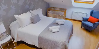 a bedroom with a bed and a blue chair at Apartamento Buen Camino in O Pedrouzo