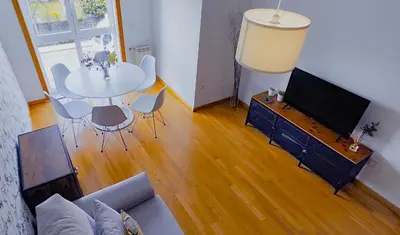 a living room with a couch and a table and a tv at Apartamento Buen Camino in O Pedrouzo