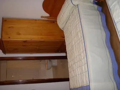 a bed in a room with a wooden ceiling at Hostal la Cuesta in Vega de Espinareda