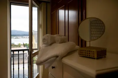 a bedroom with a bed and a mirror and a window at Chalet frente a Rapadoira.Foz in Foz