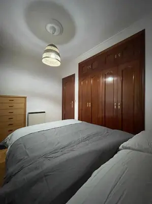a bedroom with a large bed with wooden cabinets at Appartement vistahermosa in Vivero