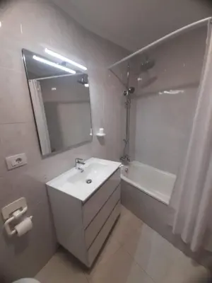 a bathroom with a sink and a tub and a mirror at Appartement vistahermosa in Vivero