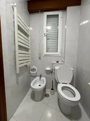 a white bathroom with a toilet and a window at Appartement vistahermosa in Vivero