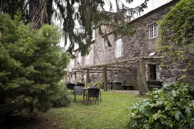 a table and chairs in front of a brick building at Pazo de Andeade in Andeade