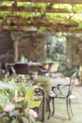 a patio with a bench and a table and some plants at Pazo de Andeade in Andeade