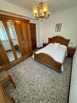 a bedroom with a bed and a chandelier at Casa Manuel in Vivero