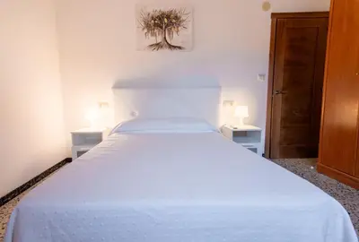 a white bed in a room with two lamps at Casa Manuel in Vivero