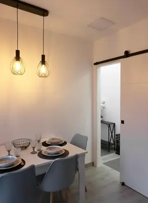 a dining room with a table and chairs and lights at El Rincón de la estación in Ourense
