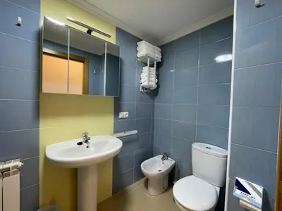 a bathroom with a white toilet and a sink at APARTAMENTO NUEVO EN BURELA - A Mariña, Galicia in Burela de Cabo