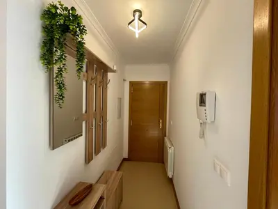 a hallway with a door and a tv on a wall at APARTAMENTO NUEVO EN BURELA - A Mariña, Galicia in Burela de Cabo