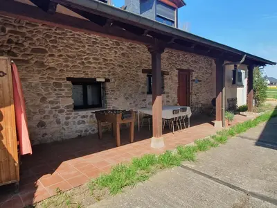 an outdoor patio with a table and a bench at Casa Rural El Bierzo Oro en el Camino in Villaverde de la Abadía