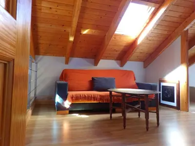 an orange couch in a room with a table at Casa Rural El Bierzo Oro en el Camino in Villaverde de la Abadía