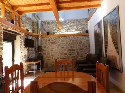 a living room with a table and a couch at Casa Rural El Bierzo Oro en el Camino in Villaverde de la Abadía