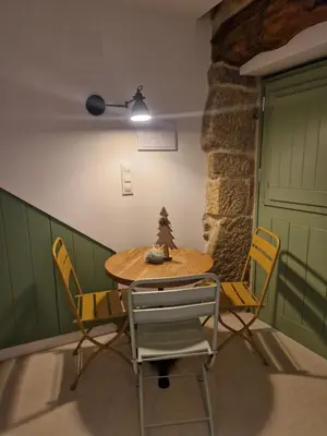 a table and chairs in a room with a green door at A casa d'abaixo in Parada del Sil
