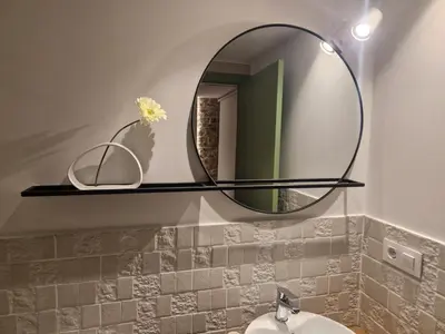 a bathroom with a round mirror above a sink at A casa d'abaixo in Parada del Sil