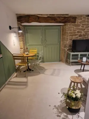 a living room with a table and chairs and a tv at A casa d'abaixo in Parada del Sil