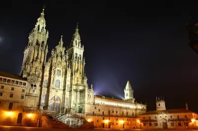 a large building with a clock tower at night at Pensión Glorioso II in Picaraña