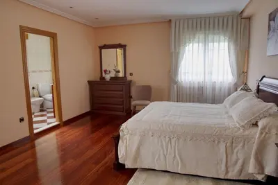 a bedroom with a bed and a bathroom with a mirror at Camino de las Mimosas: relax en un entorno idílico in Folgueras