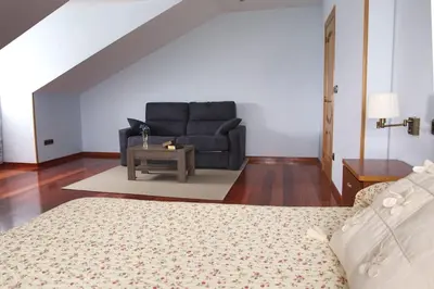 a living room with a couch and a table at Camino de las Mimosas: relax en un entorno idílico in Folgueras
