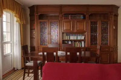a dining room with a table and a book shelf at Camino de las Mimosas: relax en un entorno idílico in Folgueras