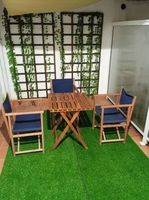 a wooden table and chairs sitting on green grass at O Picho: apartamento céntrico. in Puentedeume