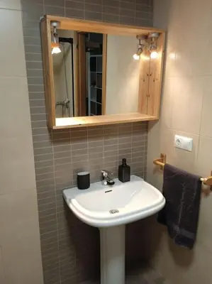 a bathroom with a white sink and a mirror at O Picho: apartamento céntrico. in Puentedeume