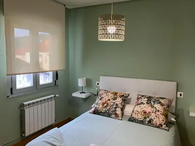 a bedroom with a white bed with two pillows at Vivienda estación in Ourense