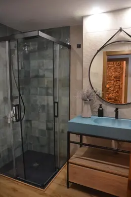 a bathroom with a shower with a sink and a mirror at Casa Sapita in Villafranca del Bierzo