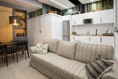 a living room and kitchen with a couch and a table at Riquiña Celanova in Celanova