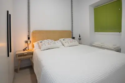 a bedroom with a large white bed and a window at Riquiña Celanova in Celanova