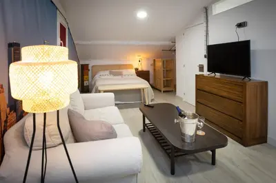 a living room with a white couch and a television at Riquiña Celanova in Celanova