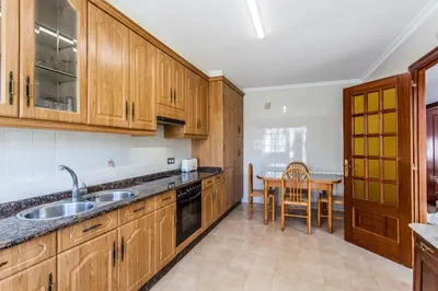 a kitchen with wooden cabinets and a table in it at Pensión O Castelo in Palas de Rei