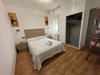 a bedroom with a bed with a teddy bear on it at Pensión O Castelo in Palas de Rei