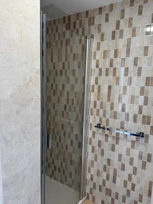 a shower with a glass door in a bathroom at Pensión O Castelo in Palas de Rei