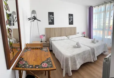 a bedroom with two beds and a mirror at Pensión O Castelo in Palas de Rei