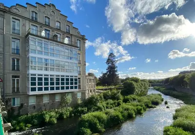 a building next to a river next to a building at Alojamiento A Tafona in Caldas de Reis