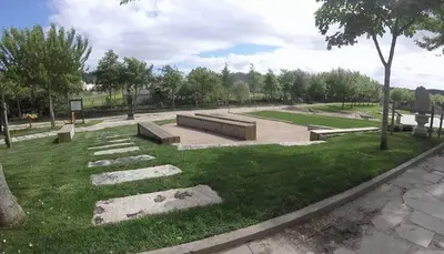 a park with benches and grass and trees at Alojamiento A Tafona in Caldas de Reis