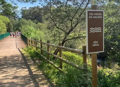 a sign on a bridge with people walking on it at Alojamiento A Tafona in Caldas de Reis