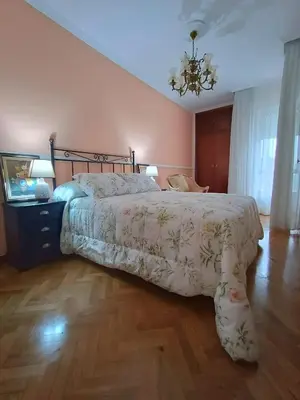 a bedroom with a large bed and a chandelier at Sobre el Puerto in Viveiro