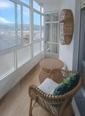 a room with a table and a chair and windows at Sobre el Puerto in Viveiro