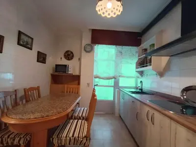 a kitchen with a sink and a table with chairs at Sobre el Puerto in Viveiro