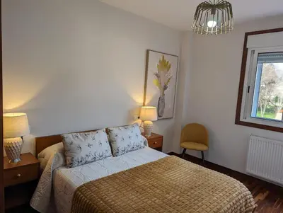 a bedroom with a bed and two lamps and a window at Don Manuel Cuntis in Cuntis