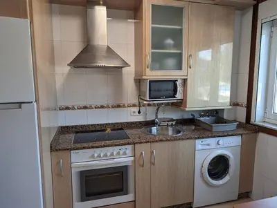 a kitchen with a sink and a stove and a microwave at Don Manuel Cuntis in Cuntis