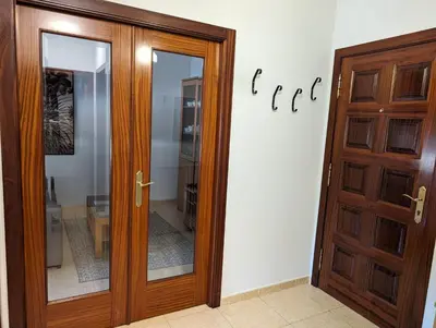 a wooden door in front of a white wall at Don Manuel Cuntis in Cuntis