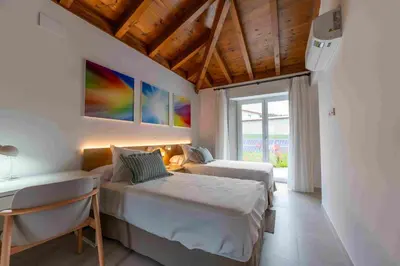a hotel room with two beds and a window at Reverence Villas Carballal in Palas de Rei