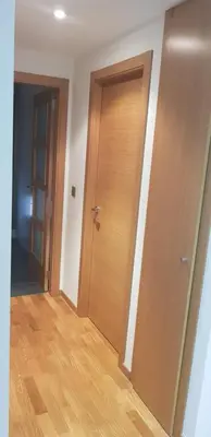 a hallway with two doors and a wooden floor at Centro Viveiro in Viveiro