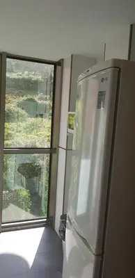 a kitchen with a refrigerator next to a window at Centro Viveiro in Viveiro