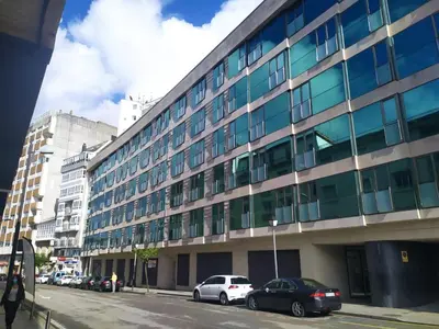 a large building with cars parked in front of it at Centro Viveiro in Viveiro